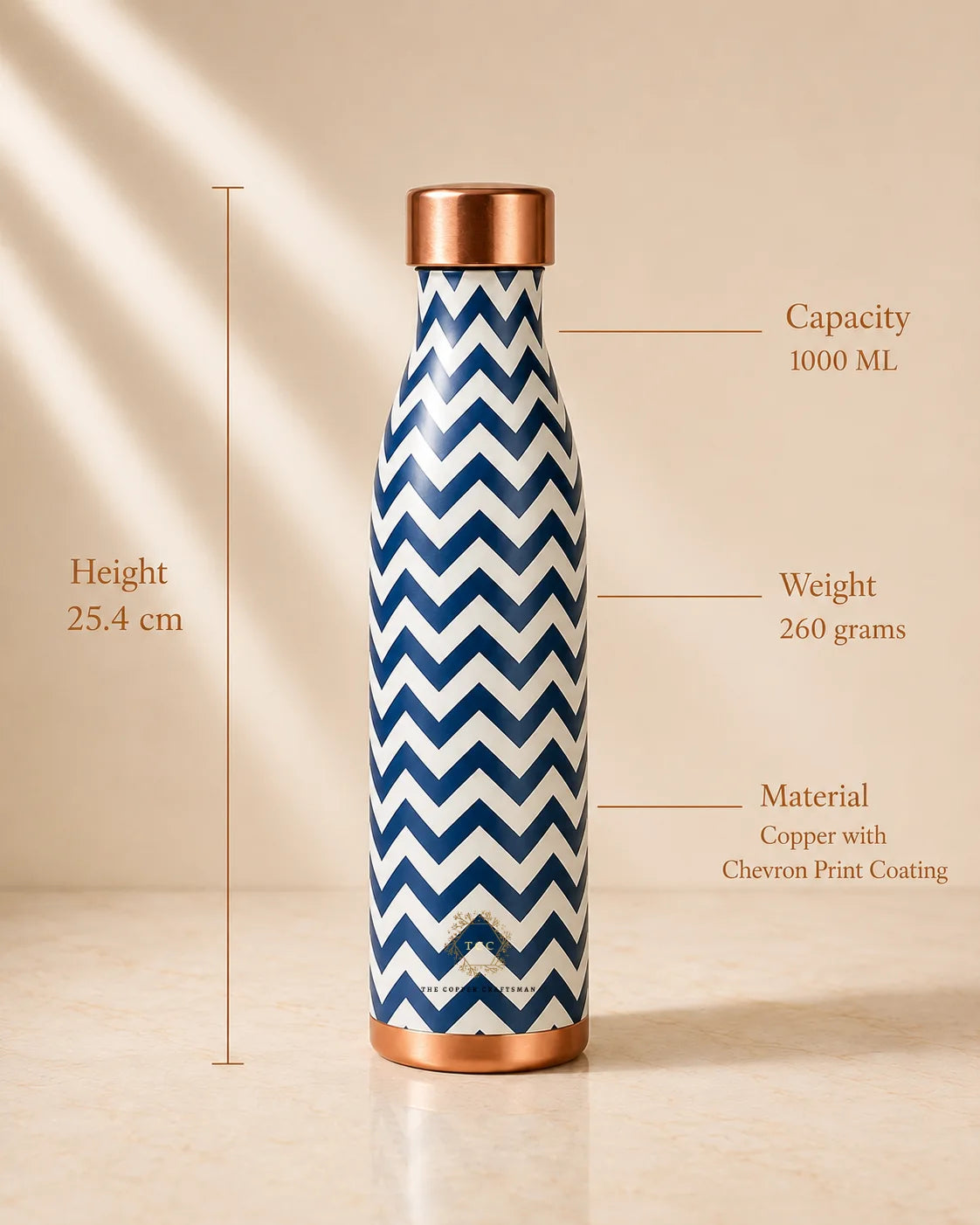 A 1000 mL copper water bottle with a navy and white chevron pattern, shown with measurement lines and text indicating its height of 25.4 cm, weight of 260 grams, and copper finish.