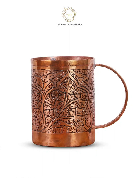 Copper mug with intricate patterns on a white background, branded 'The Copper Craftsmen'.