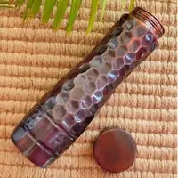 Colorful textured bottle with wooden cap on a woven mat background