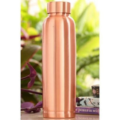 Copper water bottle with a blurred green plant background