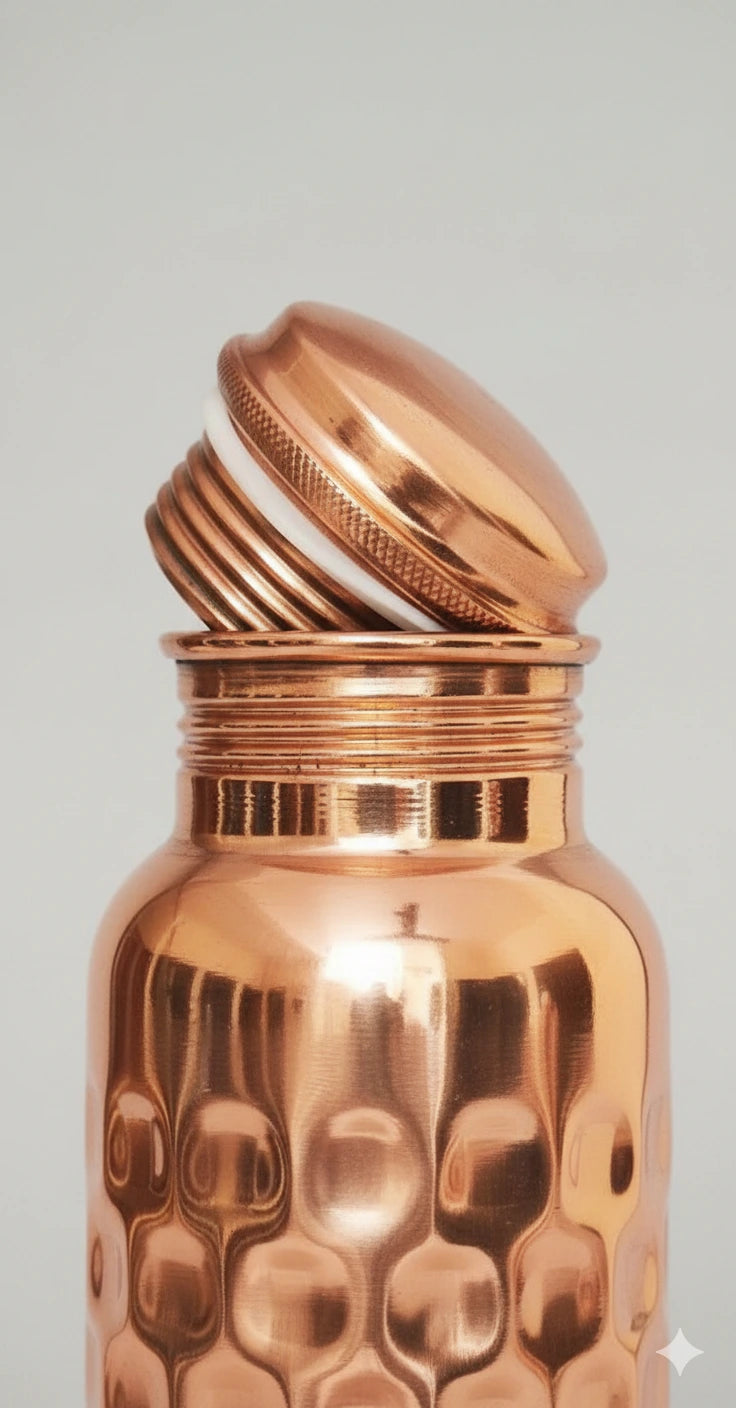 Copper water bottle with textured design on a light gray background