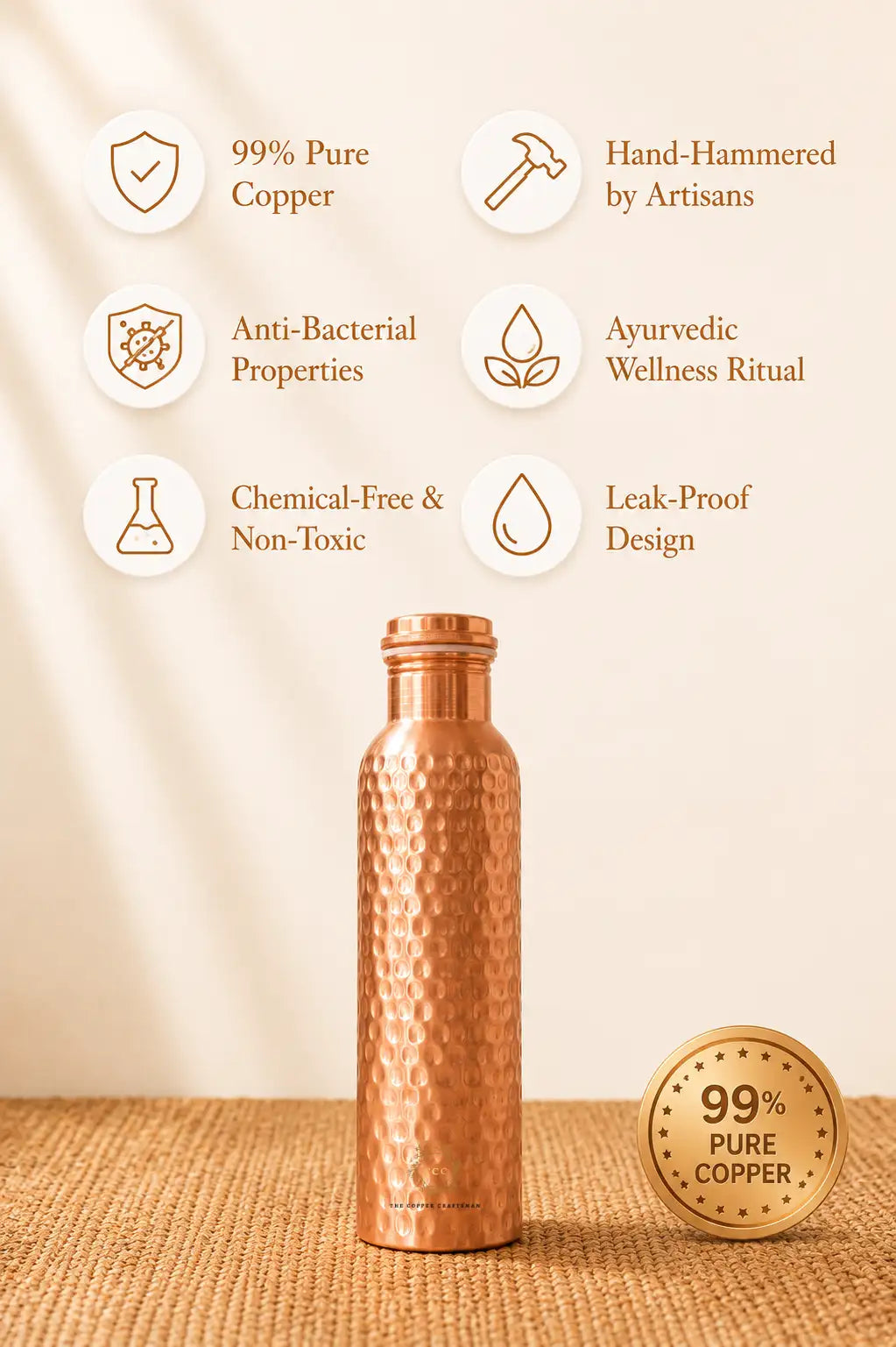 A hammered copper water bottle stands on a woven beige surface against a warm cream background. Text callouts around the bottle highlight features such as 99% pure copper, hand-hammering by artisans, anti-bacterial properties, ayurvedic wellness ritual, chemical-free and non-toxic design, and leak-proof construction.