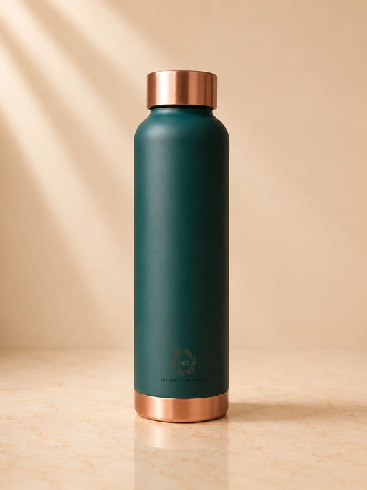A Matte green pure copper water bottle 1 litre at the top and bottom, standing on a light beige marble surface against a matching beige background with soft diagonal shadows.