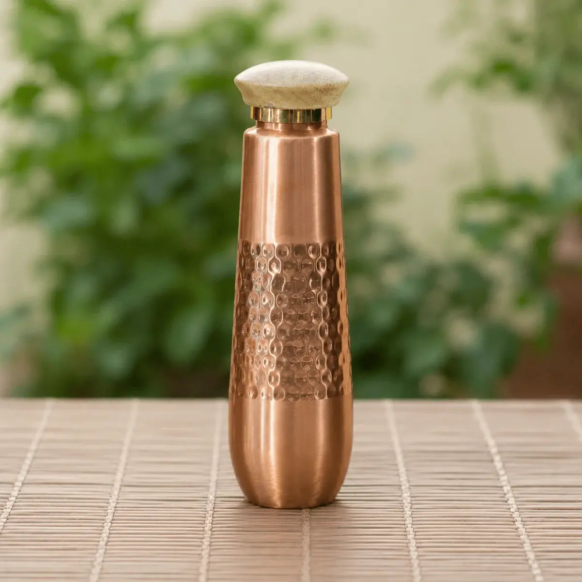 TCC Signature Hand-Hammered Copper Water Bottle on plain surface