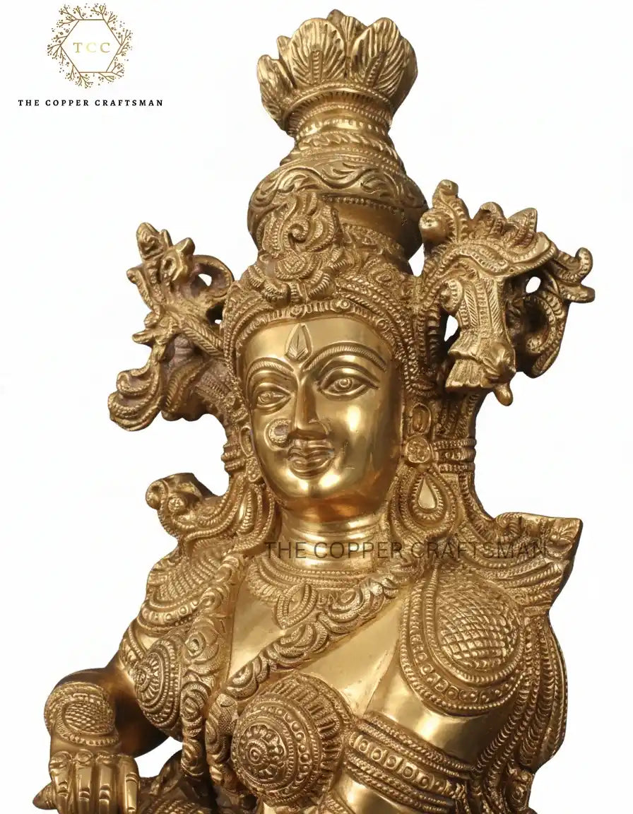 Gold-colored statue with intricate designs on a white background