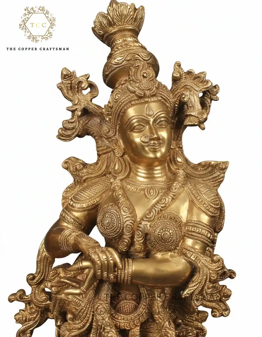 Gold-colored deity statue with intricate designs on a white background