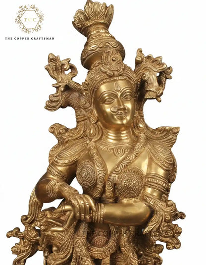 Gold-colored deity statue with intricate designs on a white background