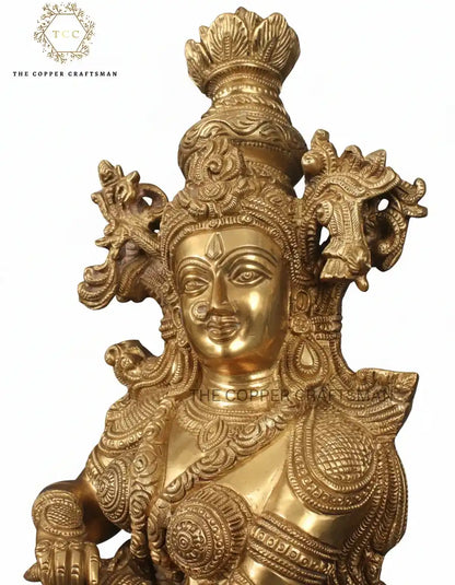 Gold-colored statue with intricate designs on a white background