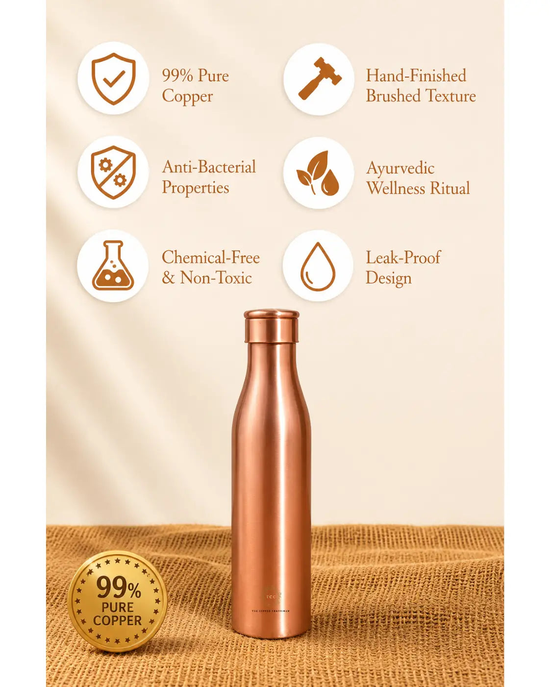 A Traditional Pure Copper Water Bottle 1 L with benifts stands on a burlap-textured surface against a warm beige background. White circular icons with brown text highlight features such as 99% pure copper, hand-finished brushed texture, anti-bacterial properties, ayurvedic wellness ritual, chemical-free and non-toxic design, and leak-proof construction.