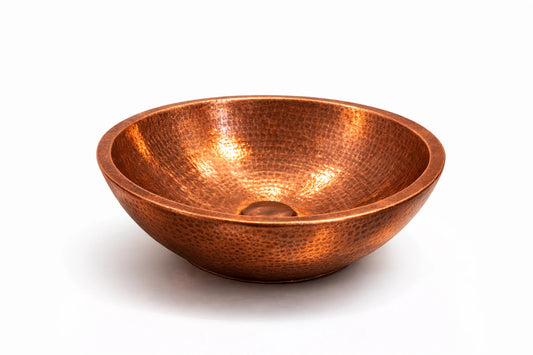 Copper bowl with a textured surface on a white background