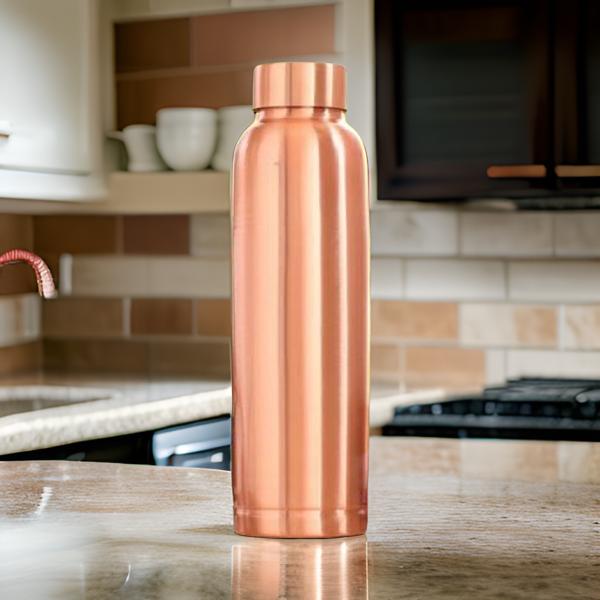 Copper water bottle on a kitchen counter with blurred background
