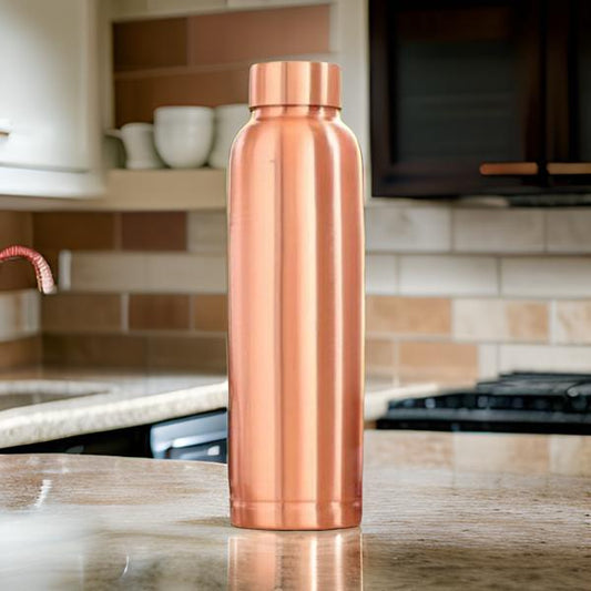 Copper water bottle on a kitchen counter with blurred background