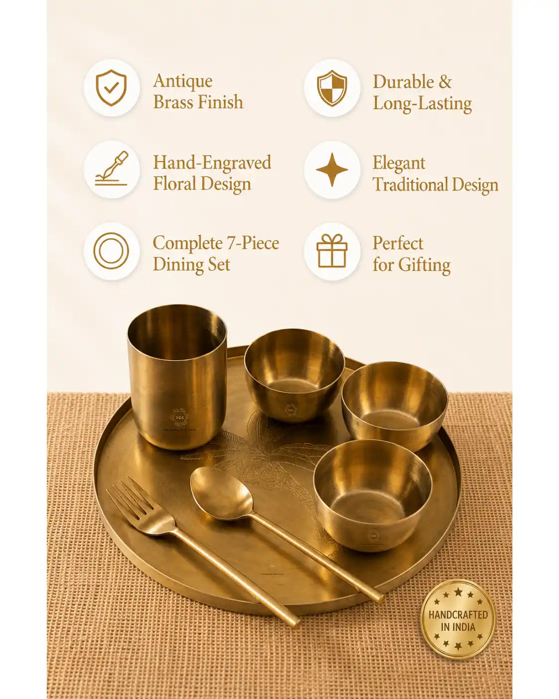 A 7-piece brass dining set displayed on a round matching tray, featuring a cup, bowls, spoon, and fork. The image includes marketing text highlighting antique brass finish, hand-engraved floral design, and traditional design, with a 'Handcrafted in India' badge.