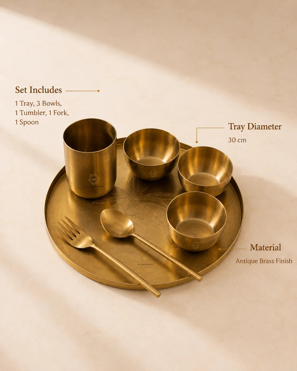 An antique brass dinnerware set arranged on a round matching tray, with text callouts listing included items and dimensions: one tray, three bowls, one tumbler, one spoon, and one fork. The set is photographed on a warm beige surface with soft shadows.