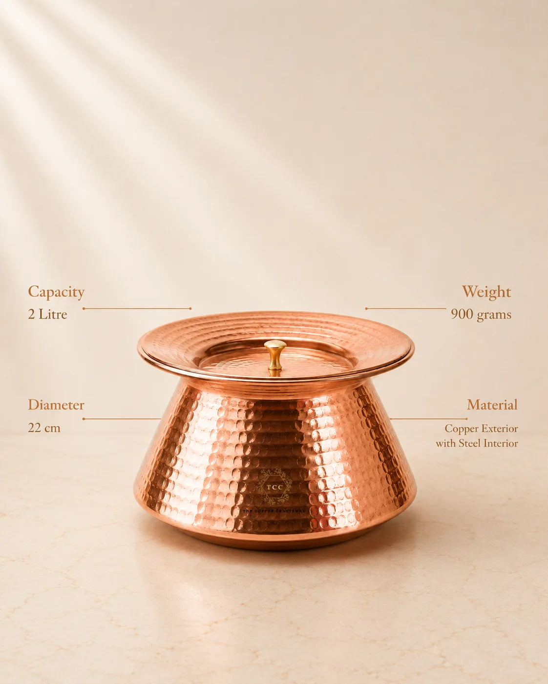 A traditional-copper-handi-india on a light beige surface, with callout lines and text showing capacity 2 litre, weight 900 grams, diameter 22 cm, and material copper exterior with steel interior.